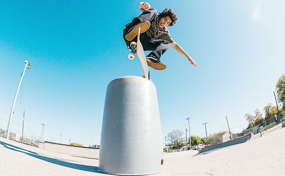 chico en skate saltando una pilona